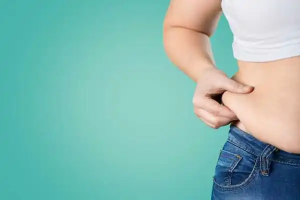 Image of woman pinching her love handles to show weight gain Wembley